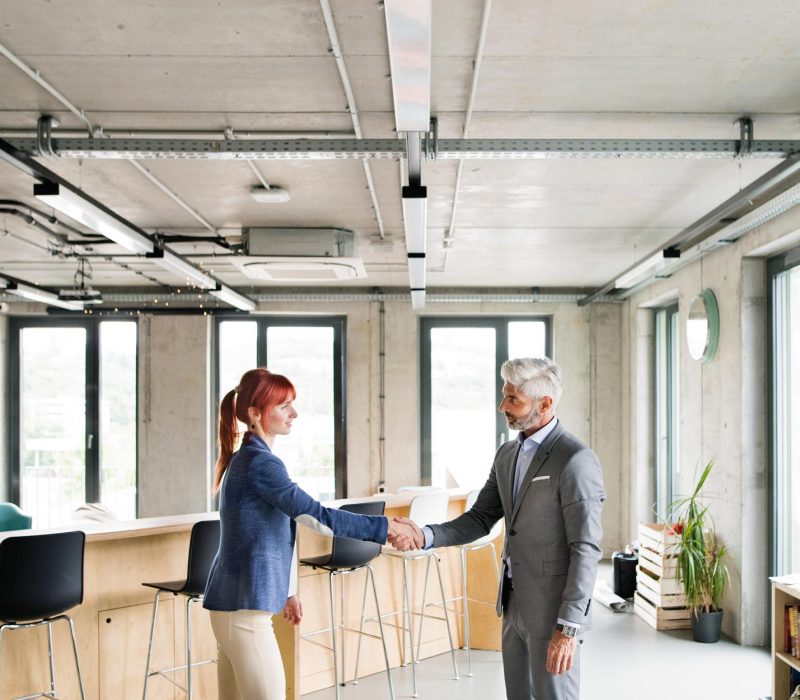 two-business-people-in-the-office-shaking-hands-PWRS4YC.jpg